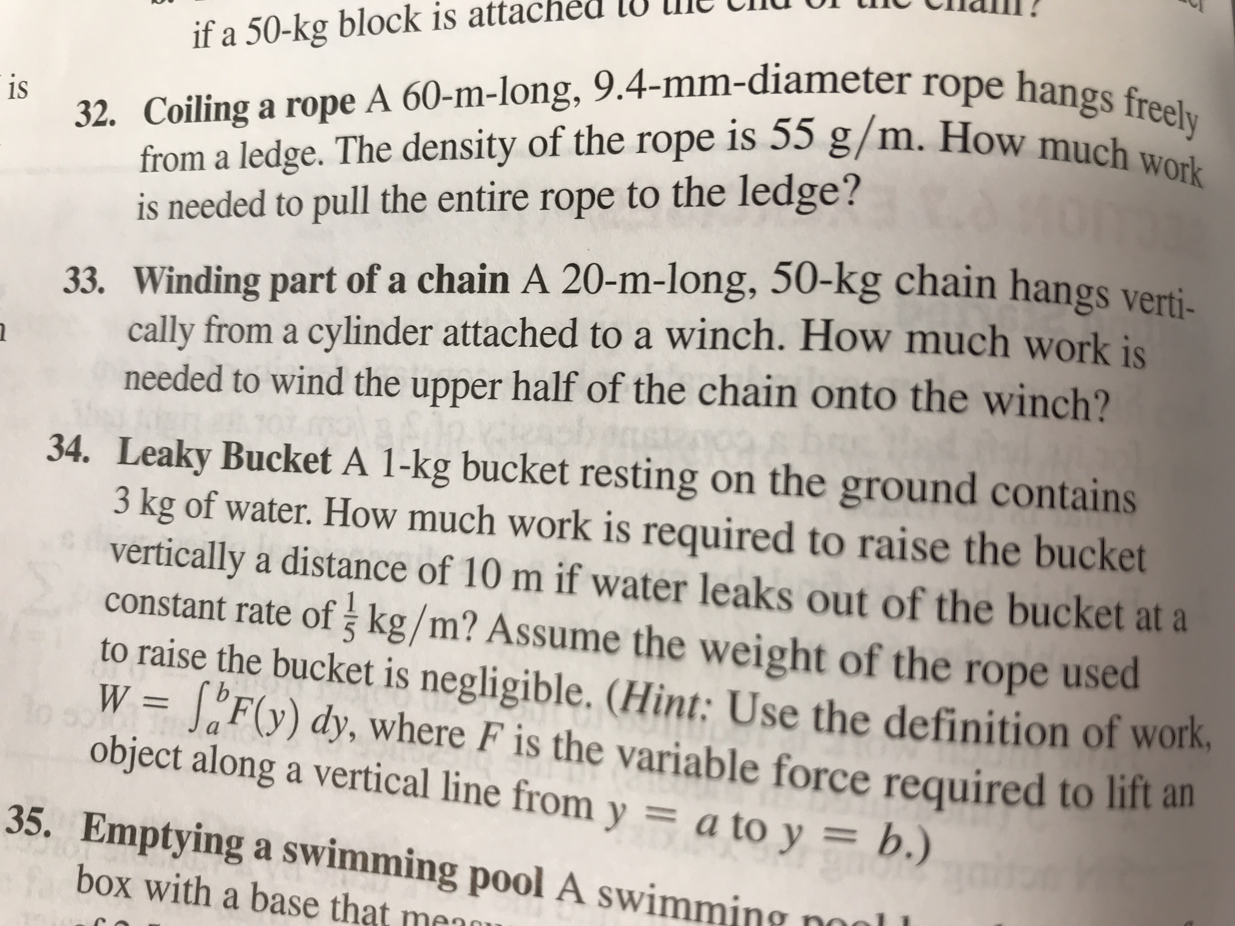 u
Cilalll!
if a 50-kg block is attached l0 le
from a ledge. The density of the rope is 55 g/m. How ms eely
is needed to pull the entire rope to the ledge?
iS
32. Coiling a rope A 60-m-long, 9.4-mm-diameter rope hangs
33. Winding part of a chain A 20-m-long, 50-kg chain hangs verti-
ally from a cylinder attached to a winch. How much work is
needed to wind the upper half of the chain onto the winch?
34. Leaky Bucket A 1-kg bucket resting on the ground contains
3 kg of water. How much work is required to raise the bucket
vertically a distance of 10 m if water leaks out of the bucket at a
constant rate of j kg/m? Assume the weight of the rope used
to raise the bucket is negligible. (Hint: Use the definition of work
W SF() dy, where F is the variable force required to lift a
object along a vertical line from y a to y b
35. Emptying a swimming pool A swim
box with a base that mennu
ming noal
