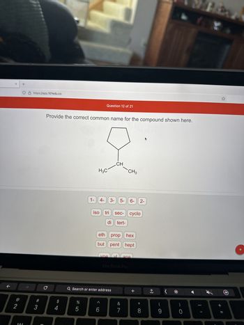 **Question 12 of 21:**

**Provide the correct common name for the compound shown here.**

The image depicts a structure of a pentagon (representing a cyclopentane ring) with a line branching downwards. This line ends in a carbon connected to two methyl groups (CH₃). The structure can be identified as a type of alkane derivative with a substituent.

**Graph/Diagram Explanation:**

- The main structure is a five-sided polygon, a cycloalkane, known as cyclopentane.
- Attached to the cyclopentane is a straight line representing a carbon atom bonded to two methyl groups (CH₃), indicating a tert-butyl group.

**Options for Naming:**

Below the diagram, there are several options presented as clickable buttons. These are prefixes, numbers, and suffixes commonly used in organic chemistry for naming compounds:

- Numbers: 1-, 4-, 3-, 5-, 6-, 2-
- Prefixes and modifiers: iso, tri, sec-, cyclo, di, tert-
- Base names: eth, prop, hex, but, pent, hept
- Suffixes and additional modifiers: yl, yl, one, ane

To correctly name the compound, these options could be combined to form the appropriate common or systematic name. Based on the structure provided, the correct name should focus on the tert-butyl group attached to the cyclopentane ring.